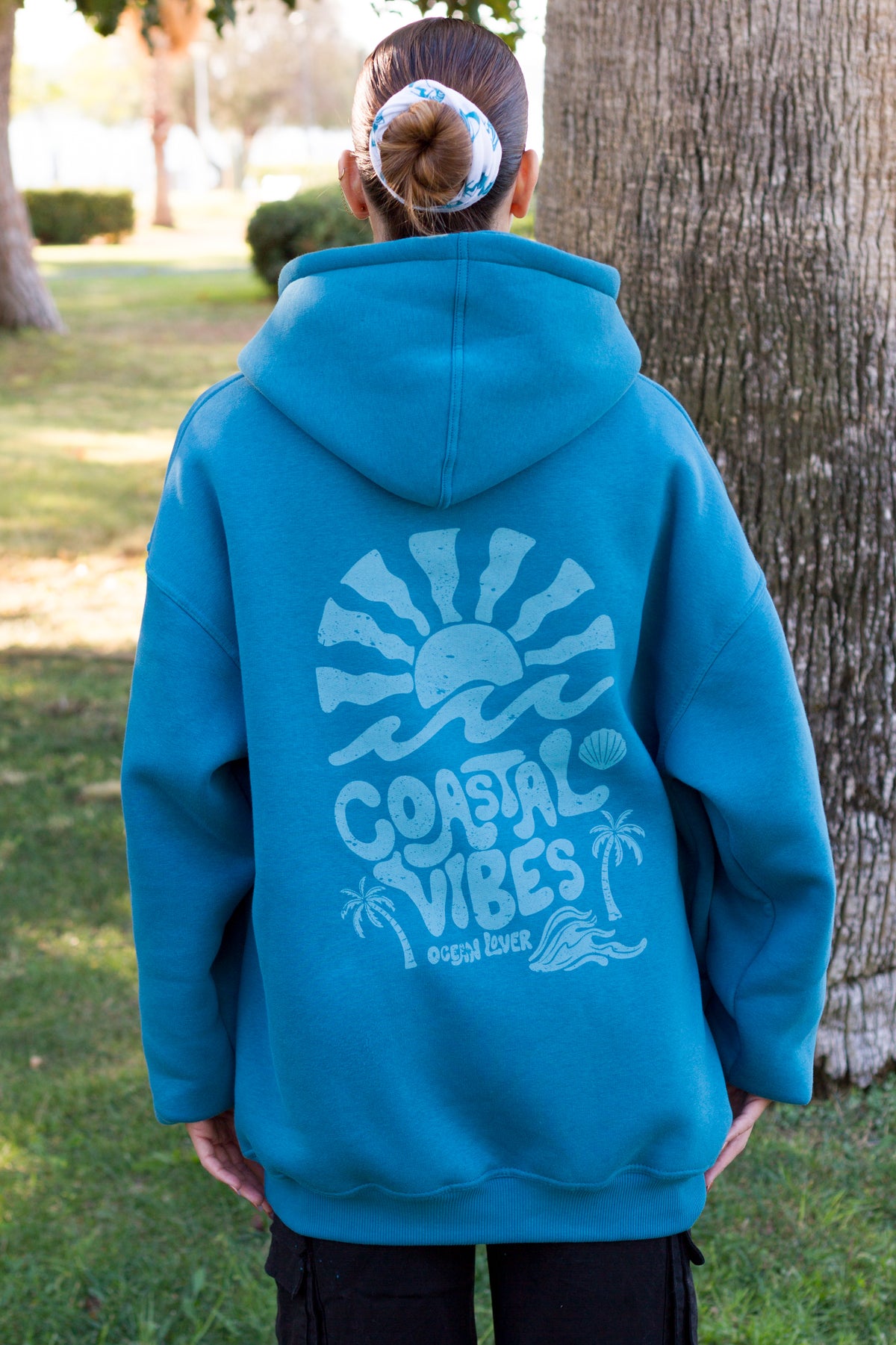 Back detail of a petrol Sevi Waves sweatshirt featuring a playful coastal graphic.