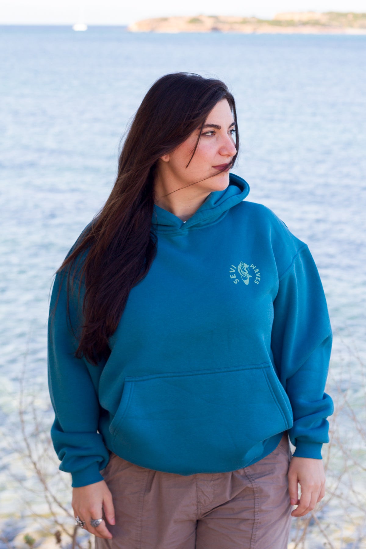Oversized petrol hoodie with a vintage-style big wave at sunset graphic, Sevi Waves collection.