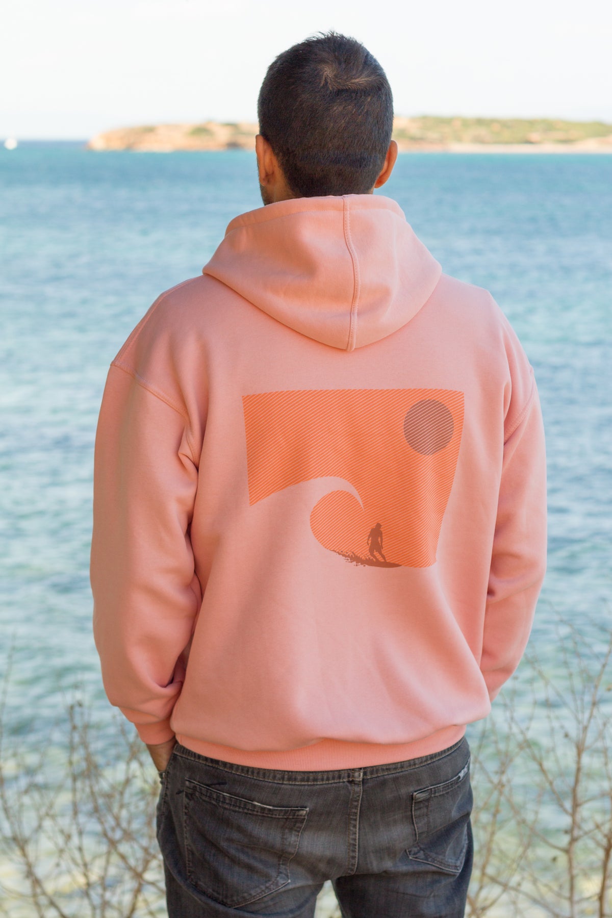 Salmon hoodie with a statement ocean wave and sunset graphic from the Sevi Waves collection.