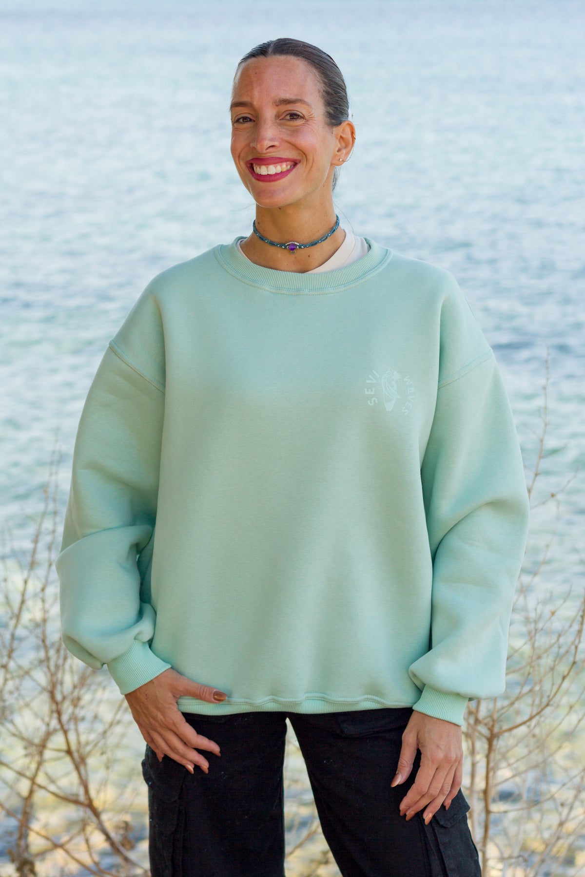Sevi Waves mint oversized crewneck sweatshirt with retro coastal graphic featuring palm trees and shells.