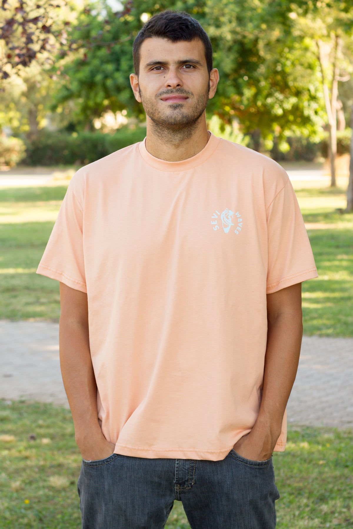 A man wearing a peach-colored crewneck t-shirt by Sevi Waves from the new collection fw26//27
