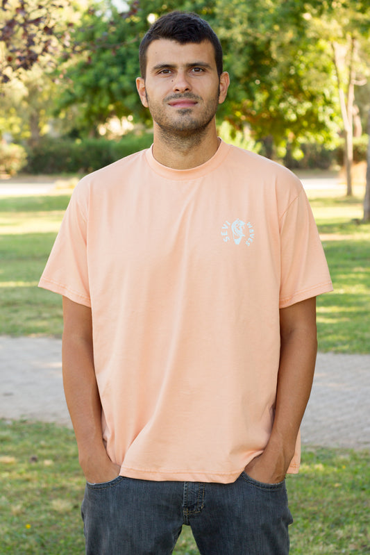A man wearing a peach-colored crewneck t-shirt by Sevi Waves from the new collection fw26//27