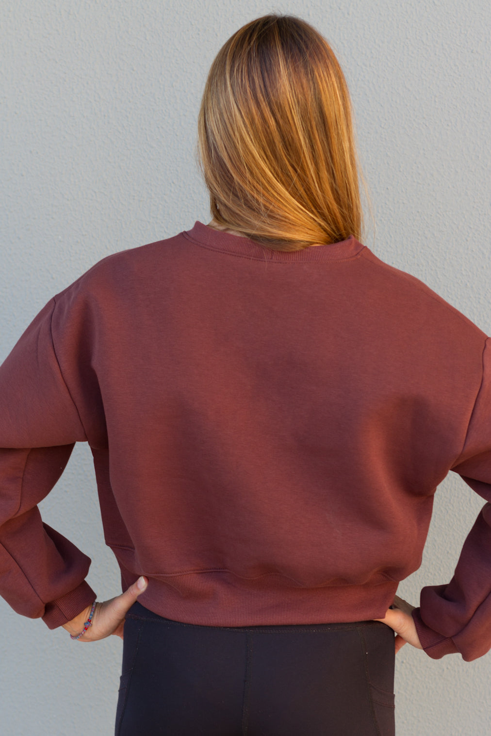 Person wearing a maroon sweatshirt against a plain background