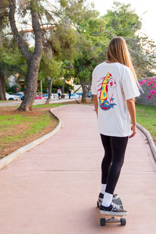 Person skateboarding on a path in a park with trees and grass.