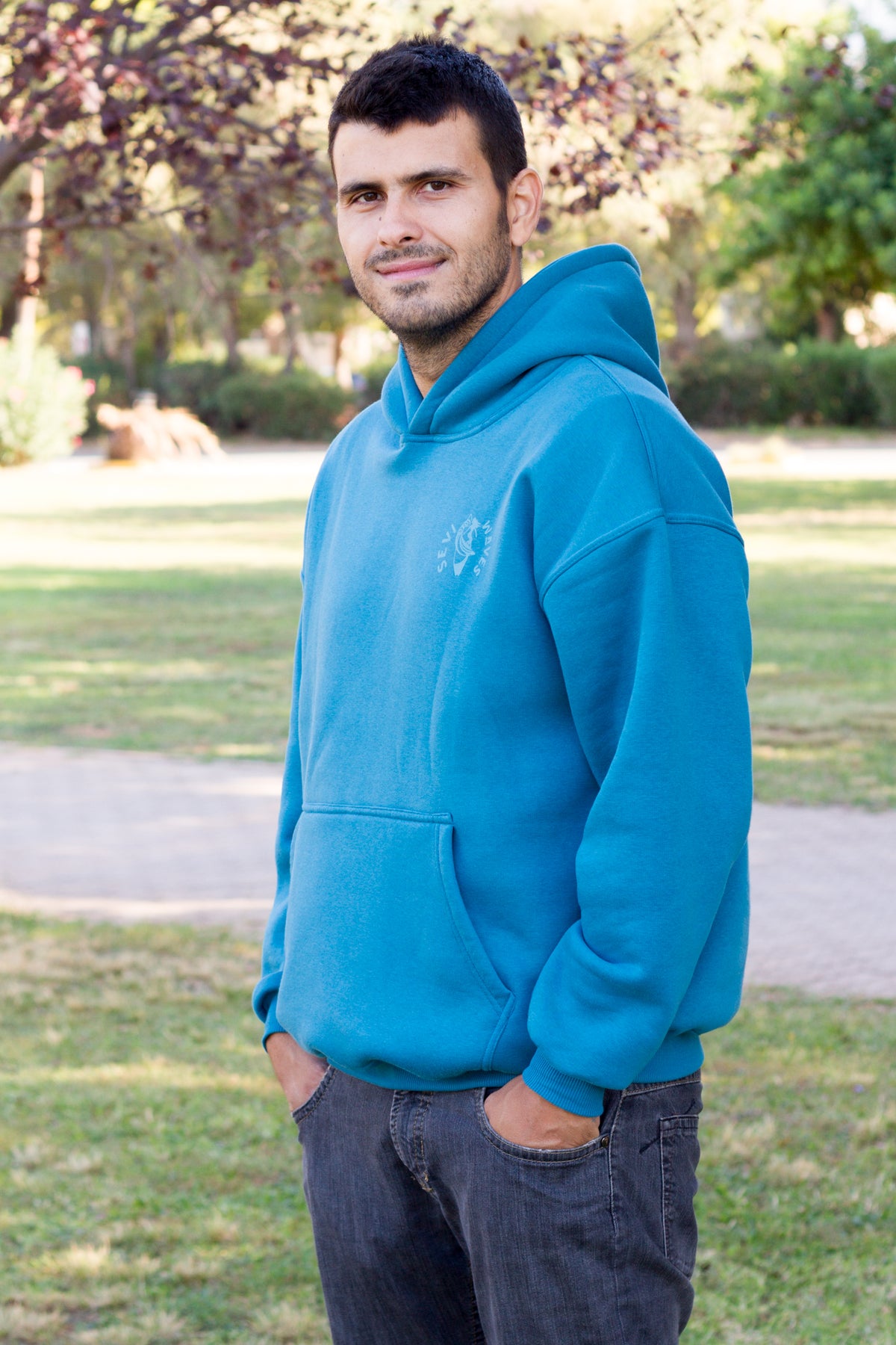 Petrol blue surf-inspired hoodie with a coastal graphic print, part of Sevi Waves TIDE SHIFT FW26/27.