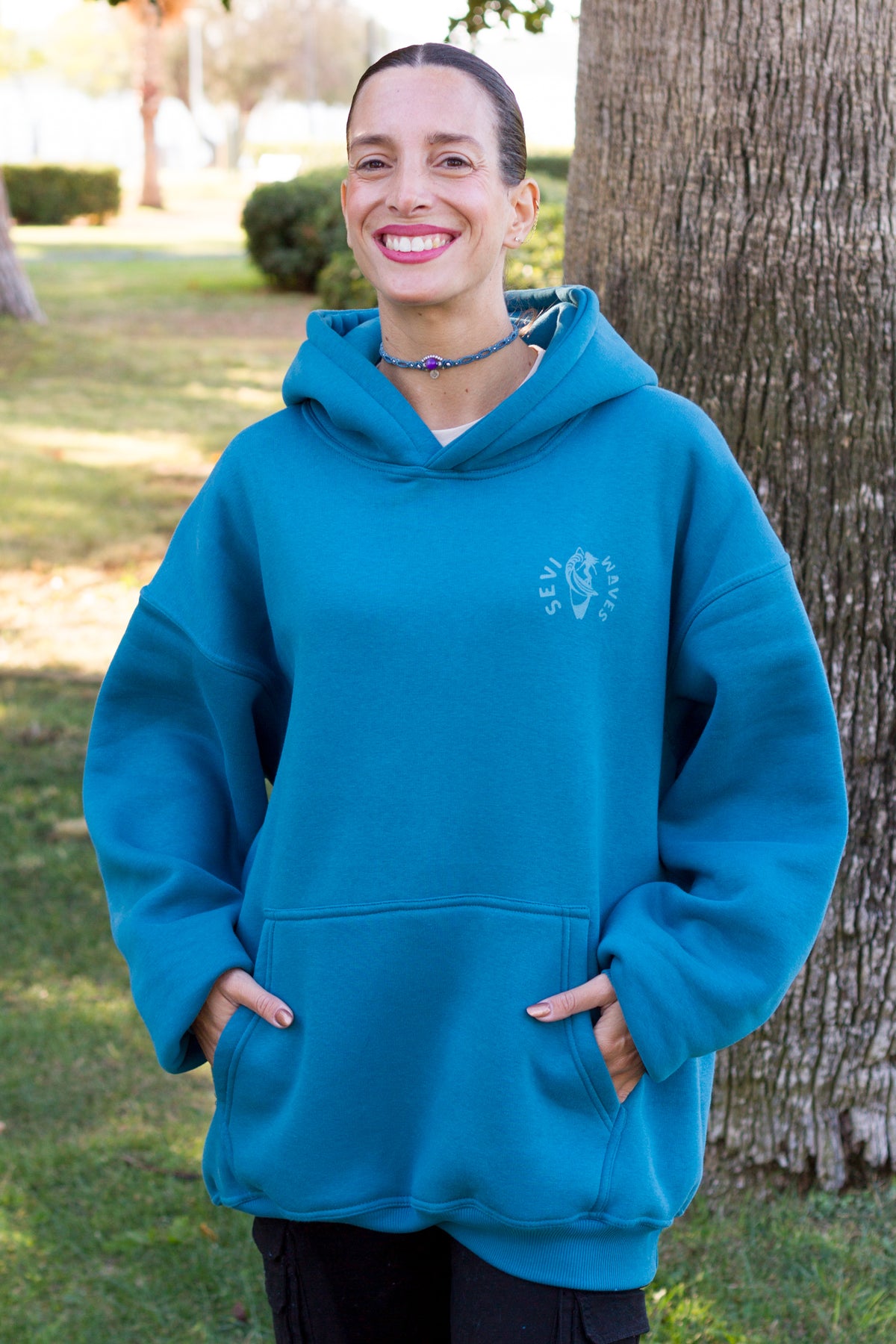 Petrol blue surf-inspired hoodie with a coastal graphic print, part of Sevi Waves TIDE SHIFT FW26/27.